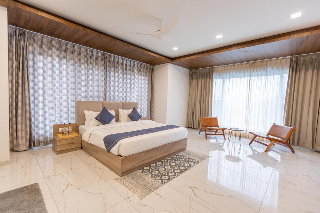 a bedroom with a king sized bed and a chair at SURAMYA-A Luxury Boutique Hotel in Udaipur