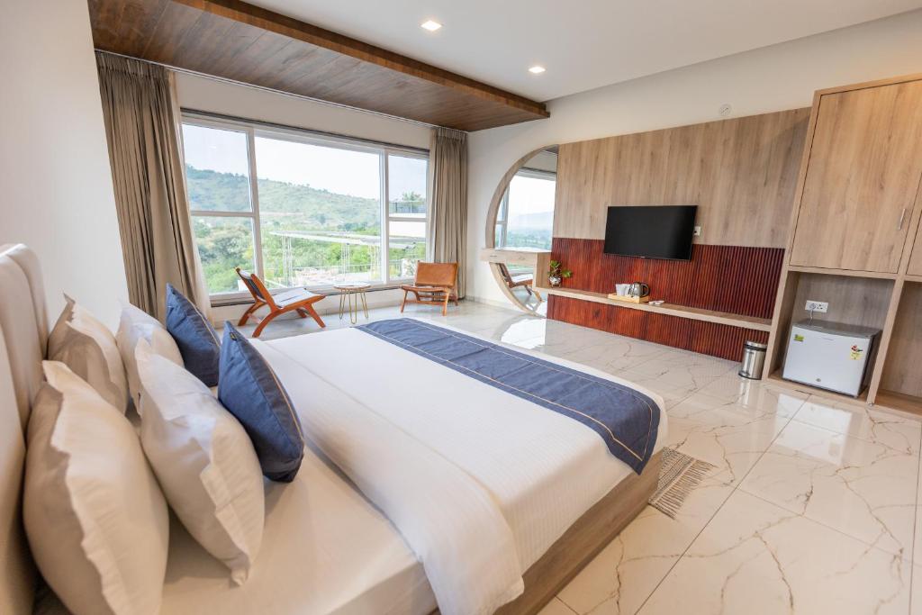 a bedroom with a large bed and a television at SURAMYA-A Luxury Boutique Hotel in Udaipur