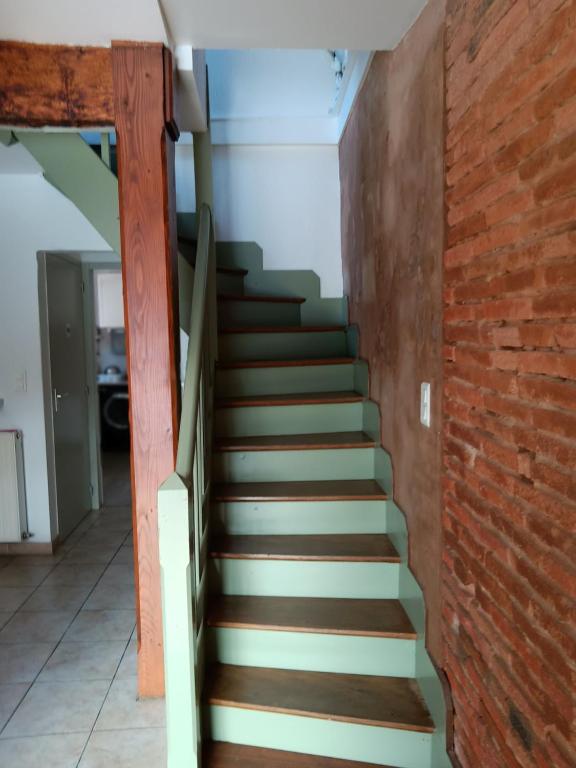 a staircase in a house with a brick wall at Auberge des chemins in Moissac