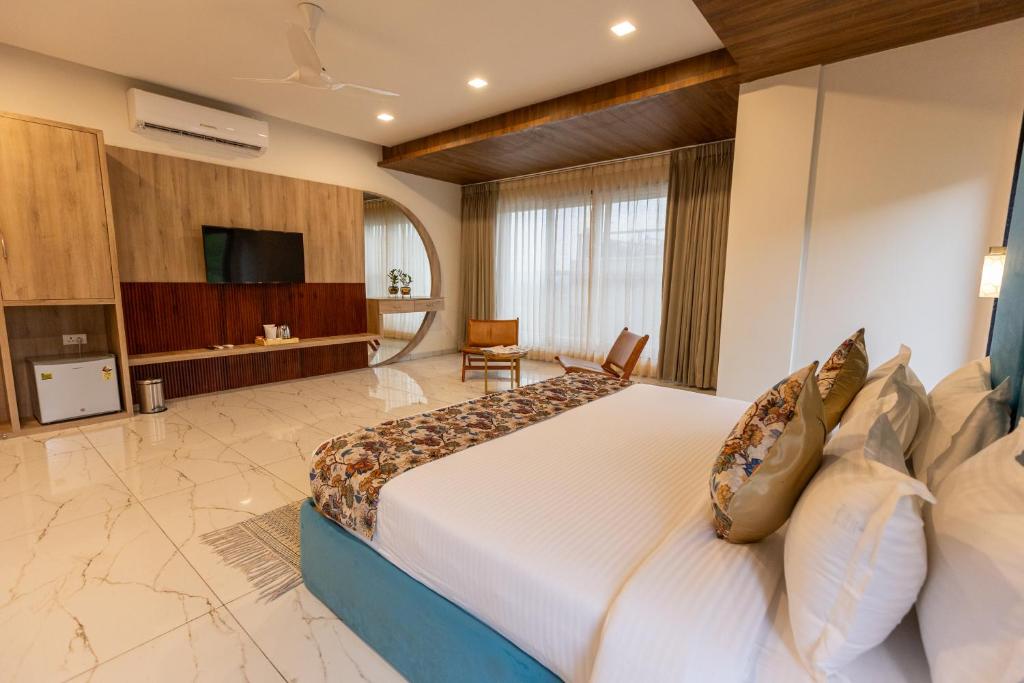 a hotel room with a large bed and a television at SURAMYA-A Luxury Boutique Hotel in Udaipur