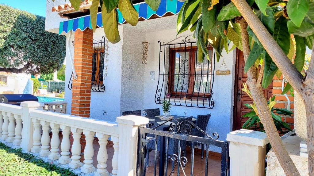 a blue house with a white fence and a porch at La Casita Denia in Els Poblets