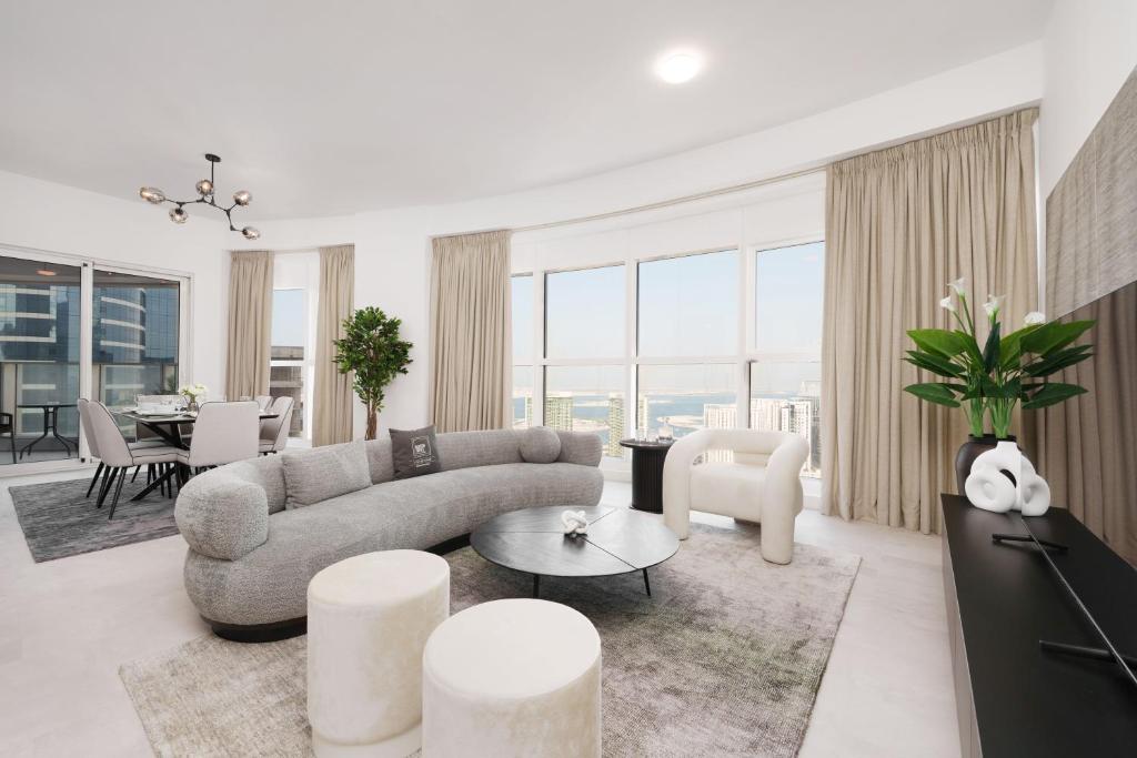 uma sala de estar com um sofá e uma mesa em Maison Privee - Elegant & Panoramic Sea View Apt on Al Reem Island em Abu Dhabi
