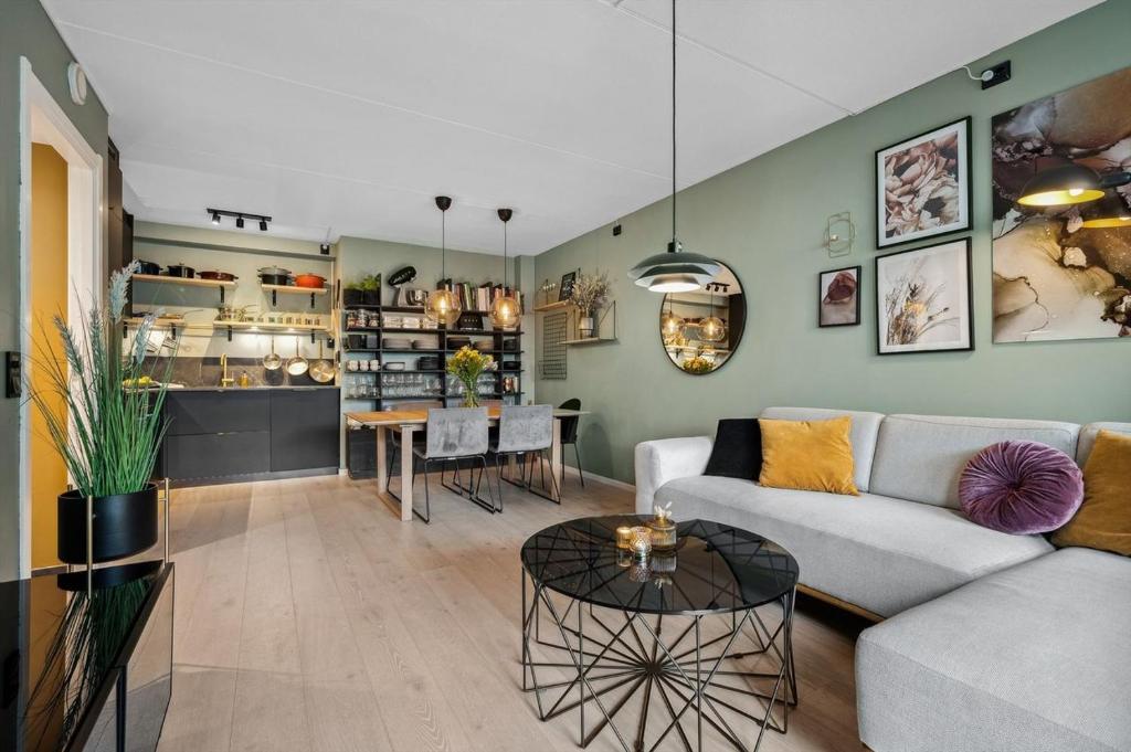 uma sala de estar com um sofá e uma mesa em Nydelig leilighet med privat terrasse mot bakgård em Oslo