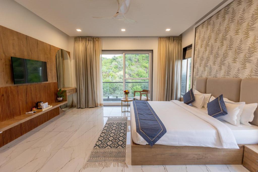 a bedroom with a large bed and a large window at SURAMYA-A Luxury Boutique Hotel in Udaipur