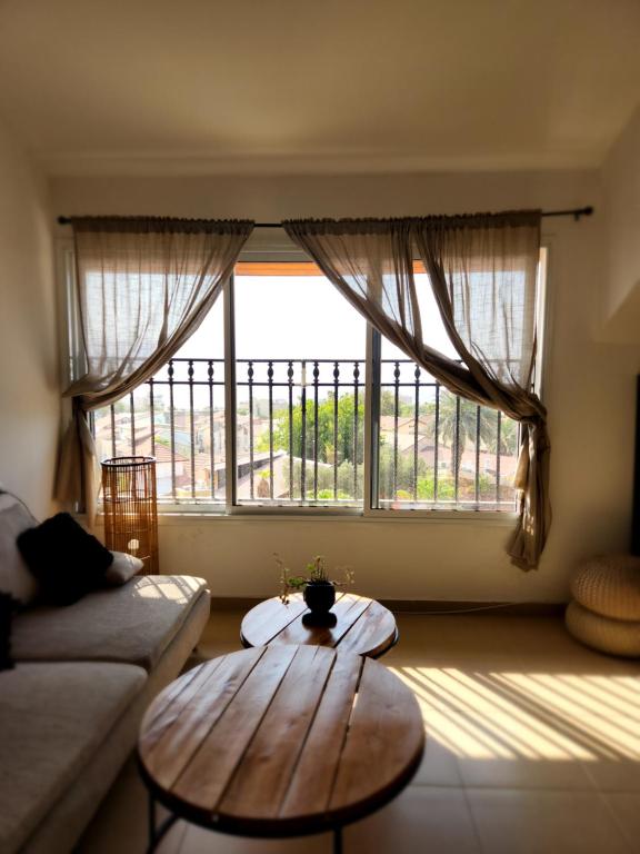 a living room with a table and a large window at לוויס פלייס levis place 52 in Eilat