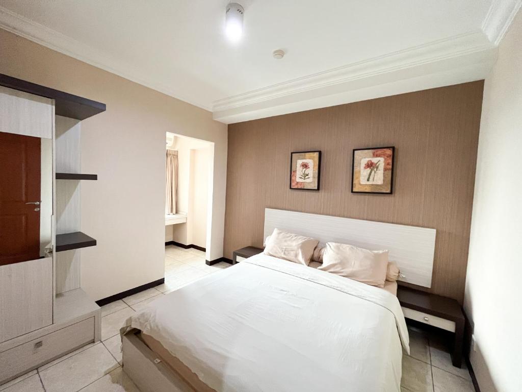 a bedroom with a large white bed with two pillows at Galeri Ciumbuleuit Apartment 1 2BR 1BA - code 26A in Bandung