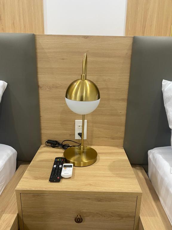 a gold lamp on a table with a remote control at Son Ca Motel in Hue