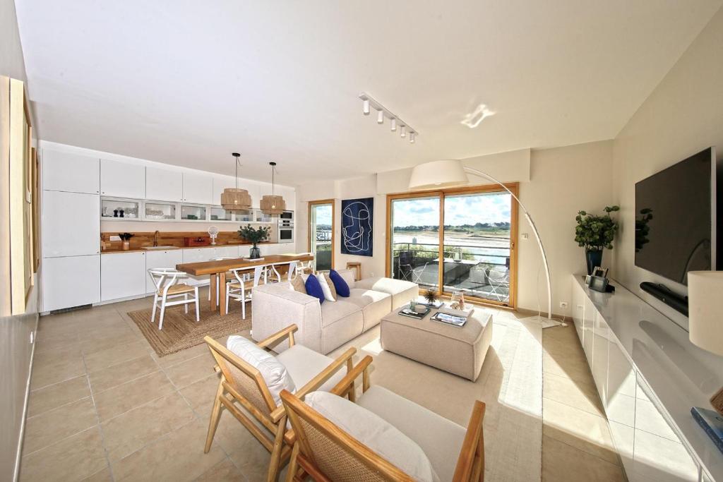 un salon avec un canapé et une table dans l'établissement La Promenade du Port - Balcon vue sur le port, à Barneville-Carteret