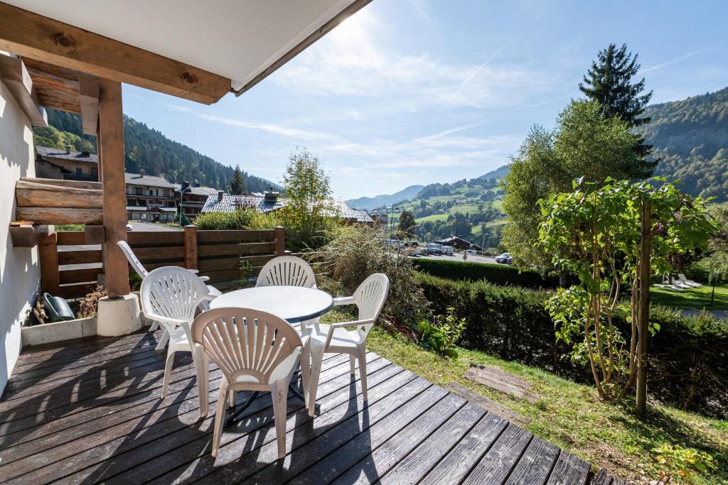 una terraza de madera con mesa y sillas. en L'Etoile Blanche - Appt vue montagne, en Flumet