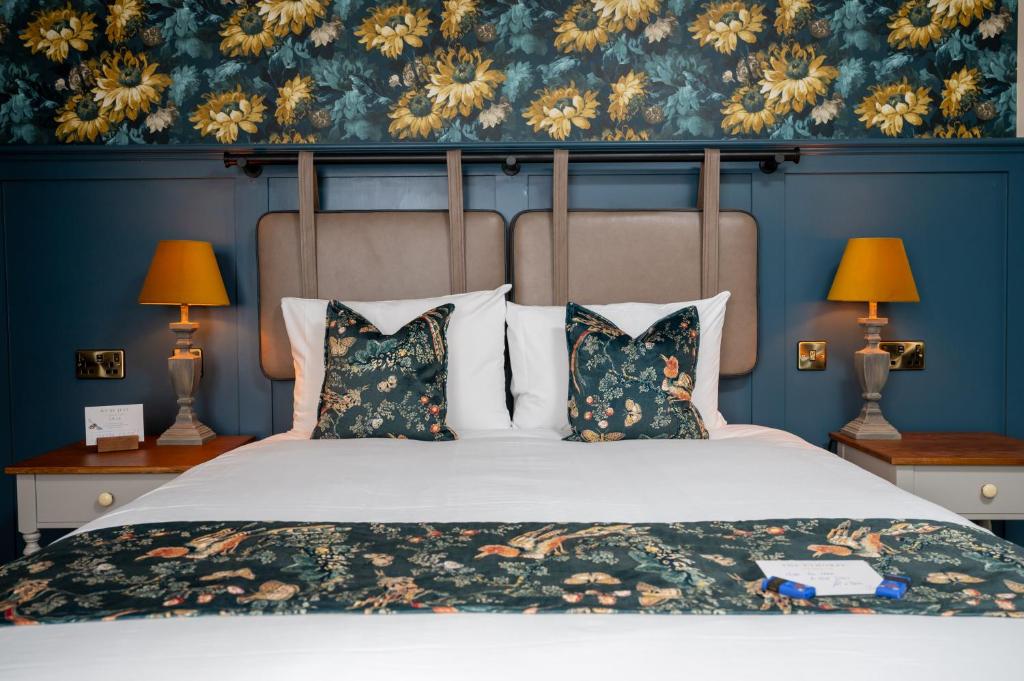- une chambre avec un grand lit aux murs bleus dans l'établissement Ethorpe Hotel by Chef & Brewer Collection, à Gerrards Cross