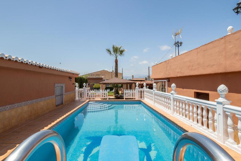 une piscine avec une clôture de fer blanc et une villa dans l'établissement Villa Torres Motril, à Motril