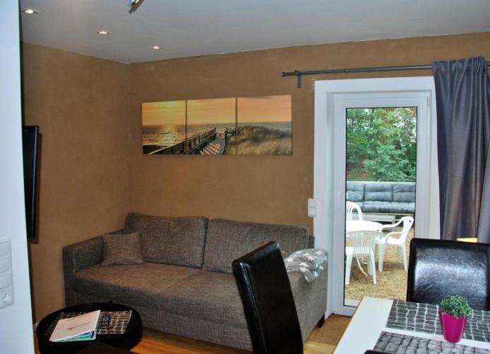 uma sala de estar com um sofá e uma mesa em Haus Santalla Whg. Unterdeck em Cuxhaven