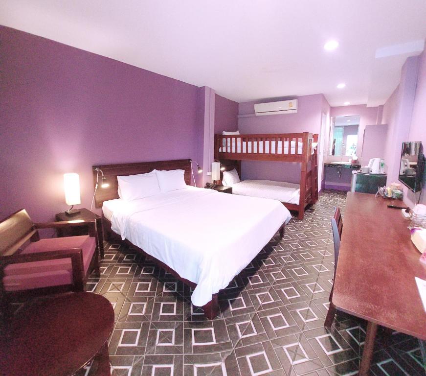 um quarto com uma cama, uma cadeira e uma mesa em Lilac Relax-Residence em Lat Krabang