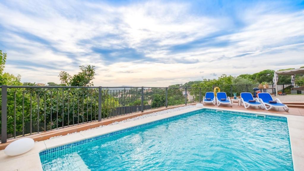 una piscina con sedie e recinzione di Costacabana - Villa Verger a Vidreres