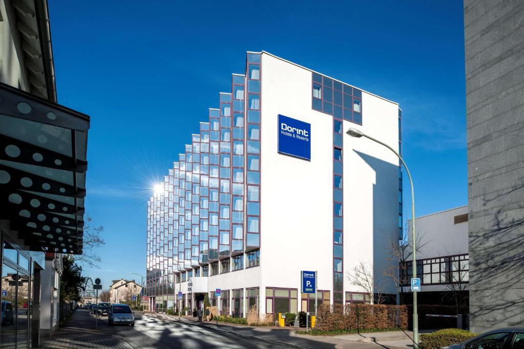 a tall white building with a blue sign on it at Essential by Dorint Frankfurt-Niederrad in Frankfurt/Main