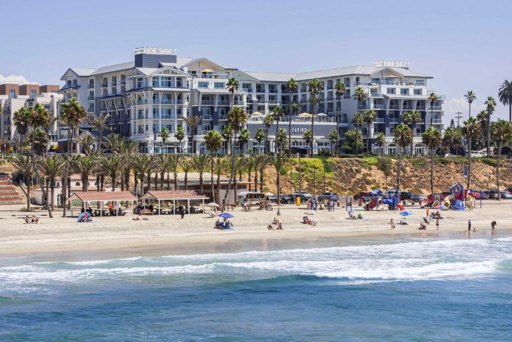 a group of people on the beach in front of a hotel at The Seabird Ocean Resort & Spa, Part of Destination Hotel by Hyatt in Oceanside