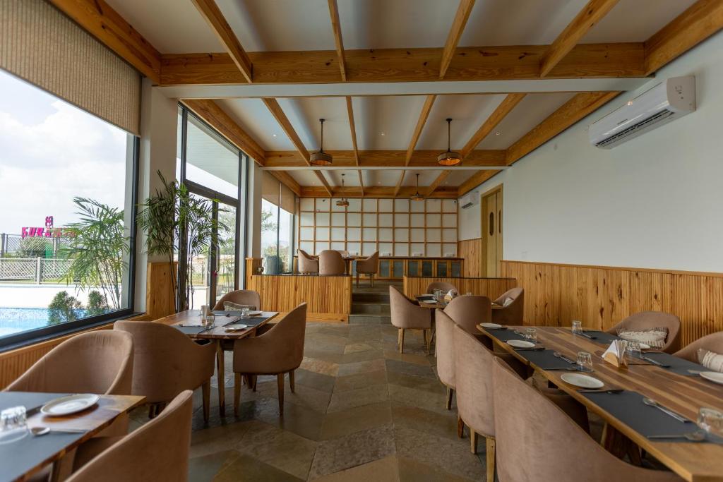a restaurant with wooden walls and tables and chairs at SURAMYA-A Luxury Boutique Hotel in Udaipur
