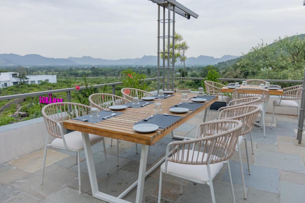 a long wooden table and chairs on a patio at SURAMYA-A Luxury Boutique Hotel in Udaipur