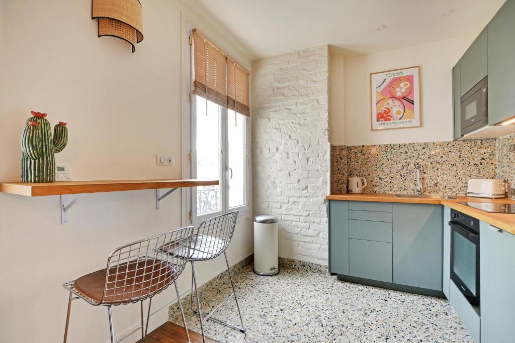 a kitchen with two chairs and a counter at Luxury Cocon by Les Maisons de Charloc Homes in Boulogne-Billancourt