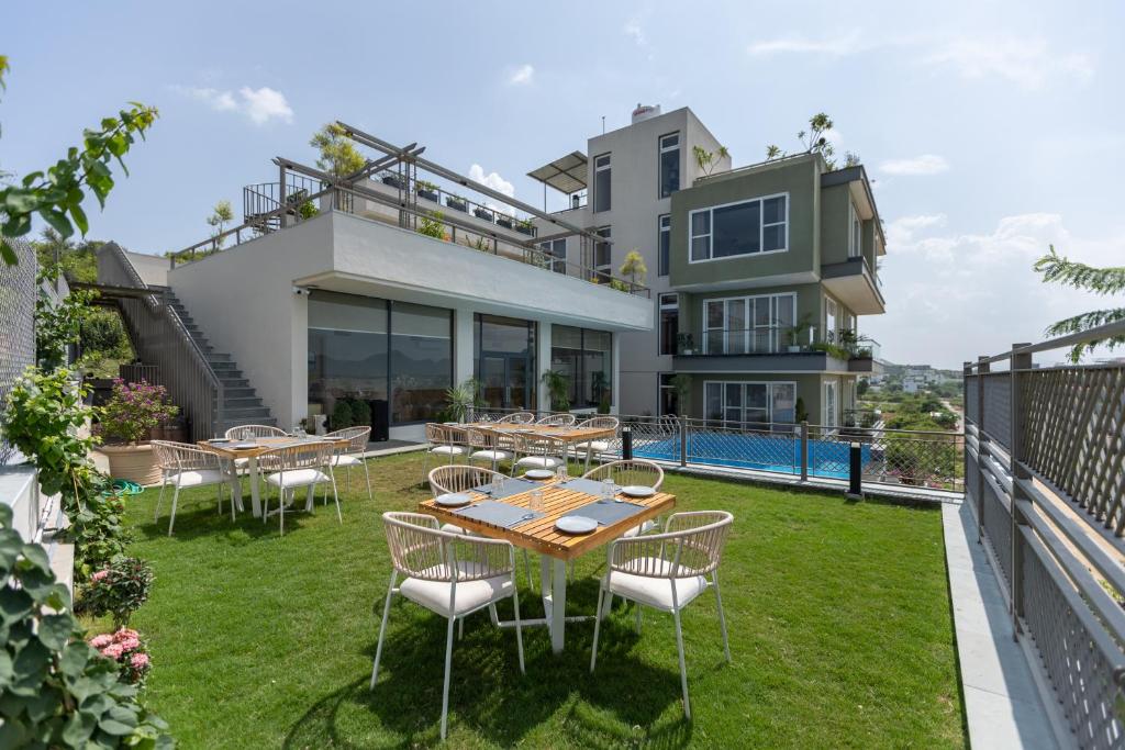 an outdoor patio with tables and chairs in front of a house at SURAMYA-A Luxury Boutique Hotel in Udaipur