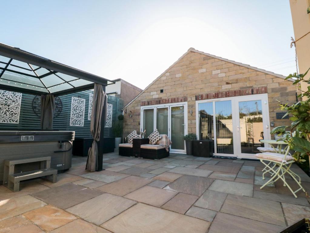 a patio with a pool and a piano at Garthgate Holiday Lodge in Malton