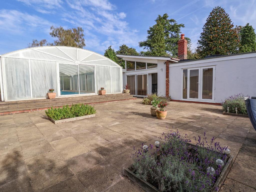 a white house with a courtyard with plants at Bramble Lodge in Northwich