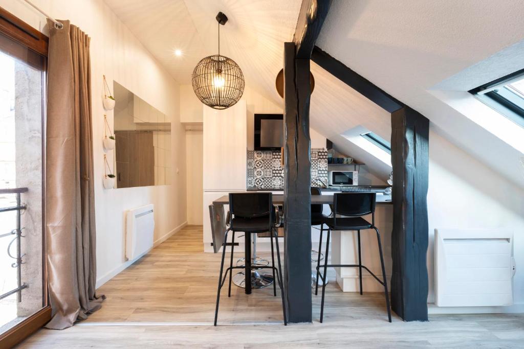 una cocina en el ático con mesa y sillas en una habitación en Le cocon Thérèse, en Metz
