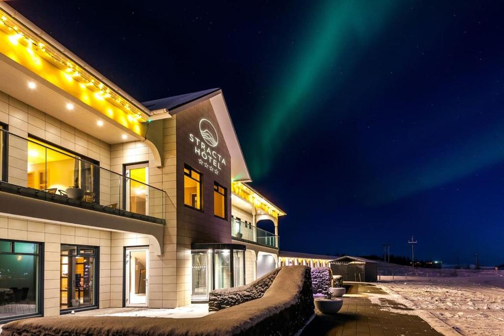 a building with the northern lights in the sky at Stracta Hotel in Hella