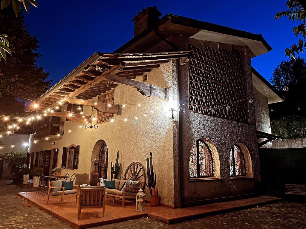 une maison avec une terrasse éclairée la nuit dans l'établissement Casale I Tigli, à Lucques