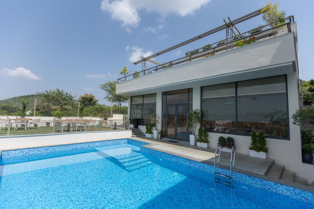 a house with a swimming pool next to a building at SURAMYA-A Luxury Boutique Hotel in Udaipur