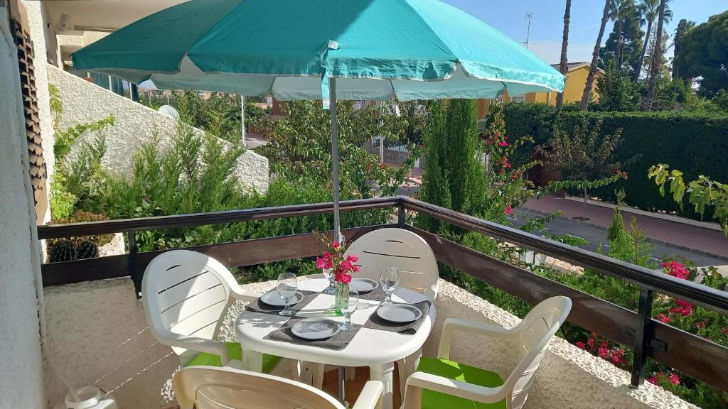 einen Tisch mit Stühlen und einem Sonnenschirm auf dem Balkon in der Unterkunft Apartment with private balcony in San Javier