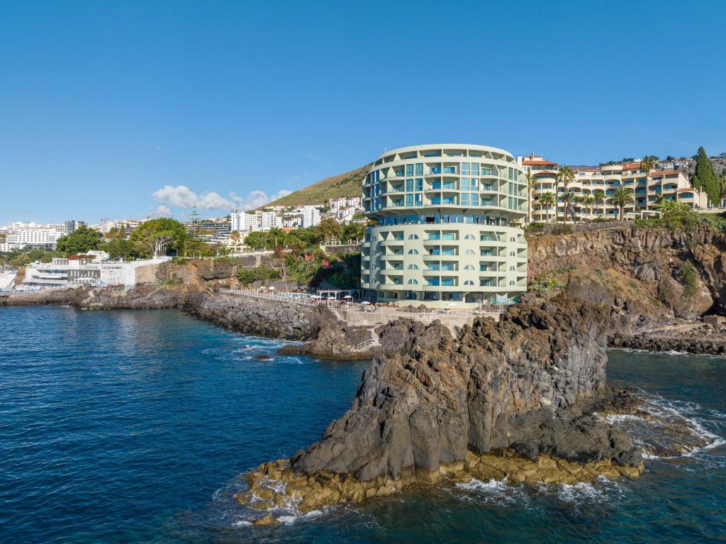 Un edificio su una scogliera vicino all'oceano di Pestana Vila Lido Madeira Ocean Hotel a Funchal