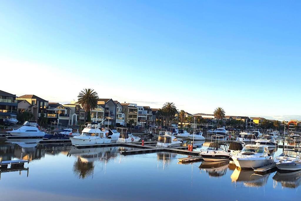 Un montón de barcos atracados en un puerto deportivo con casas en Marina Magic Getaways - Your Waterfront Retreat, en Patterson Lakes