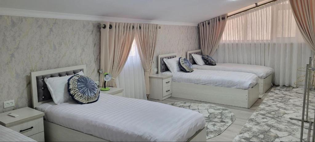 1 Schlafzimmer mit 2 Betten und 1 Zimmer mit 2 Fenstern in der Unterkunft Imran&Bek in Samarkand