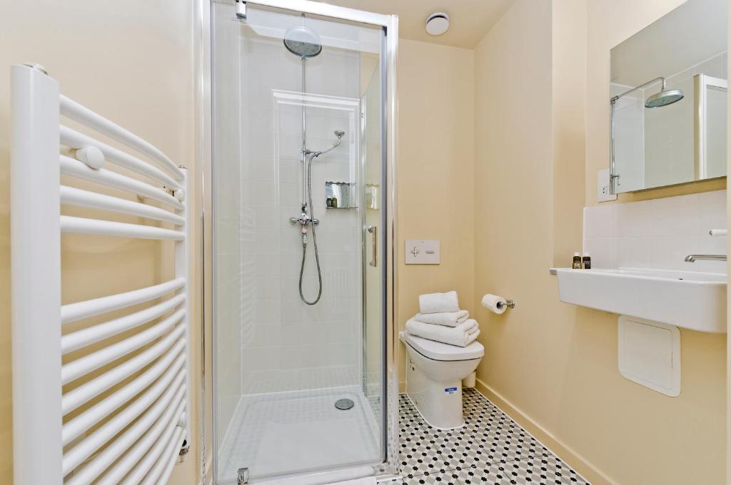 a bathroom with a shower and a toilet and a sink at Vernon House in London