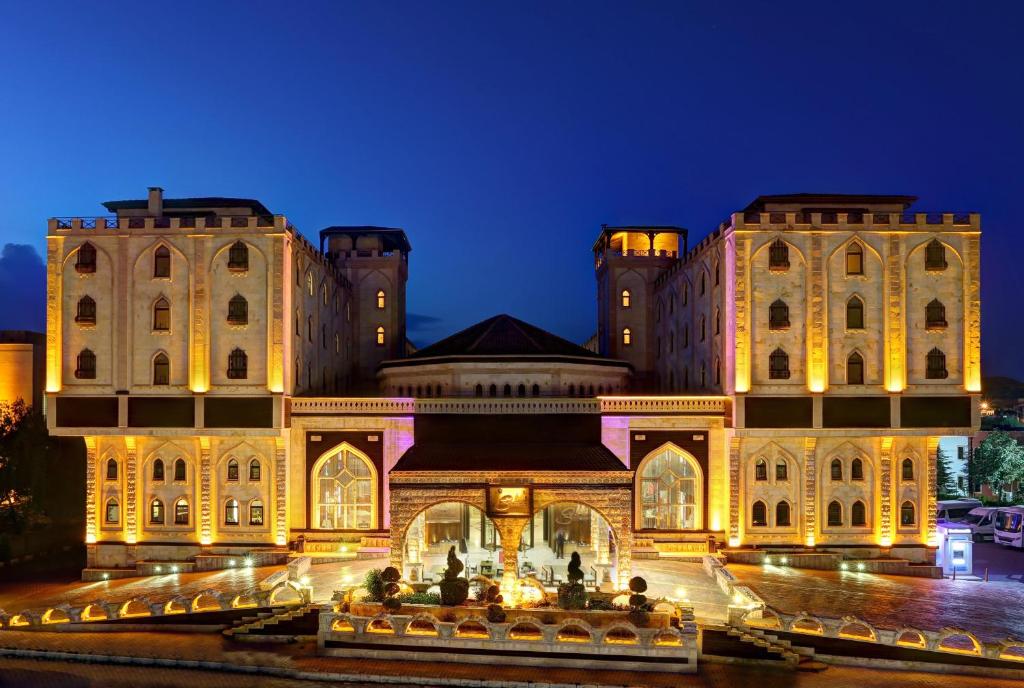 een groot gebouw dat 's nachts verlicht wordt bij Suhan Cappadocia Hotel & Spa in Avanos