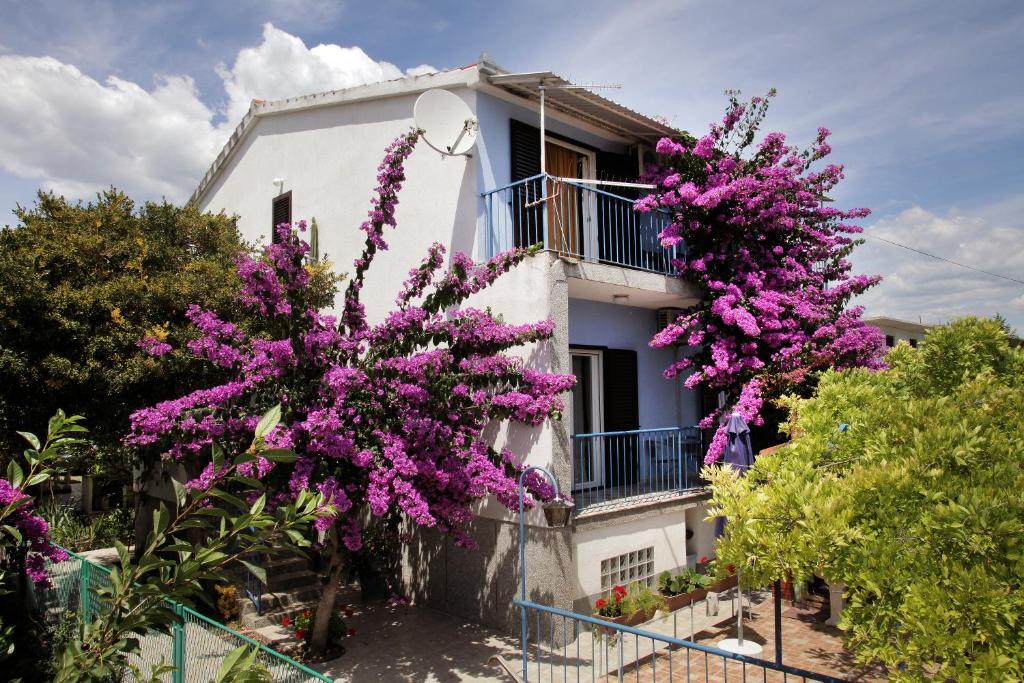 a house with purple flowers in front of it at Apartments Irena in Trogir