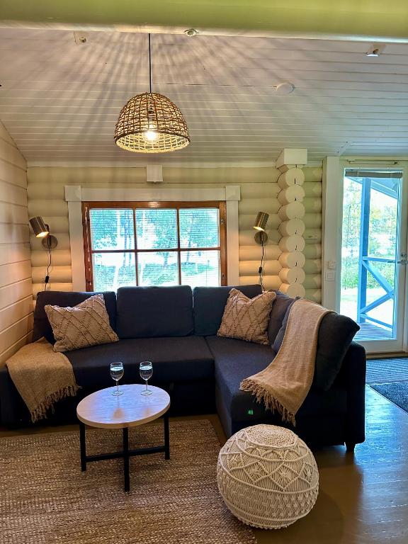 a living room with a blue couch and a table at Kuusiston majatalo in Kuusisto