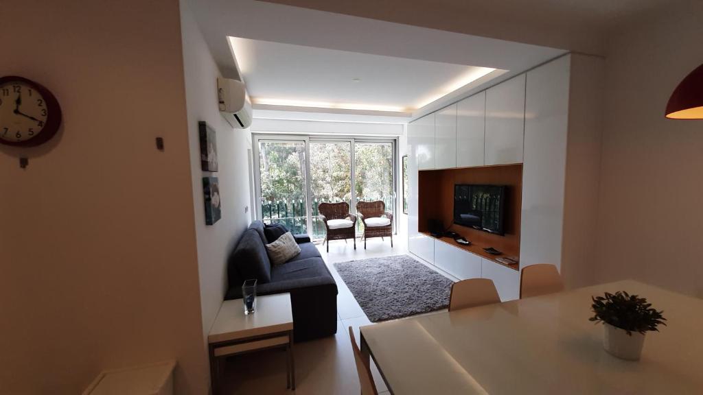uma sala de estar com um sofá, uma mesa e uma televisão em Forest View em Lisboa