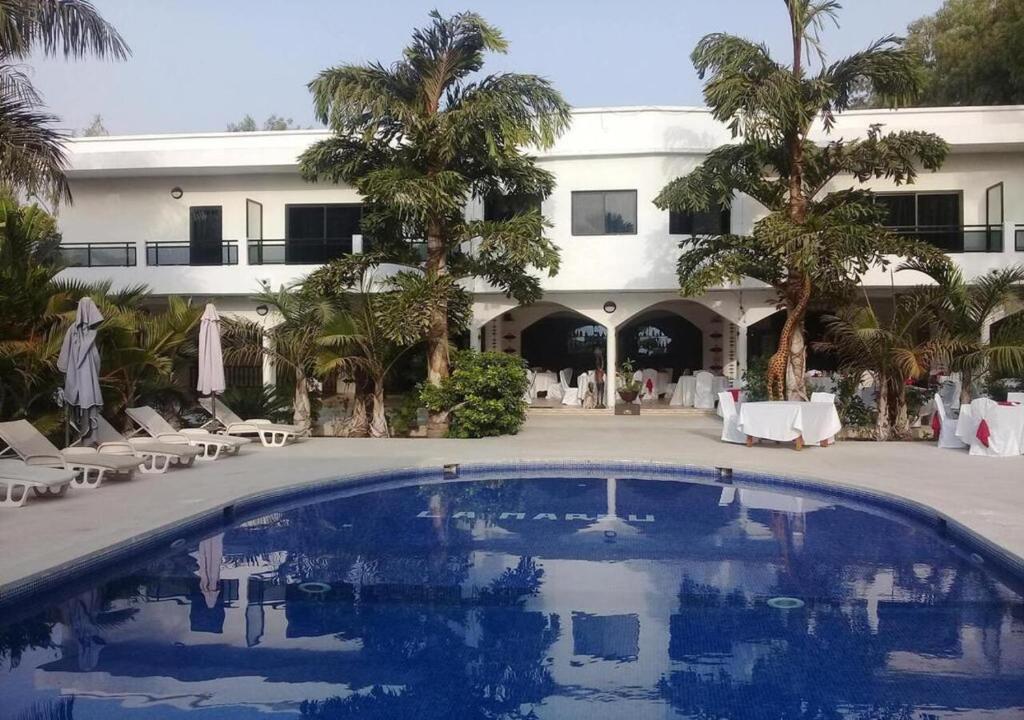 um resort com uma grande piscina em frente a um edifício em Residence Hotel La Marsu em Cap Skirring