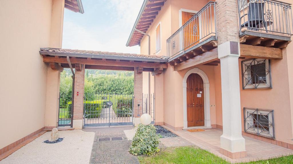 uma grande casa com um portão e um pátio em Villa Corte Barcuzzi - Italian Homing em Barcuzzi