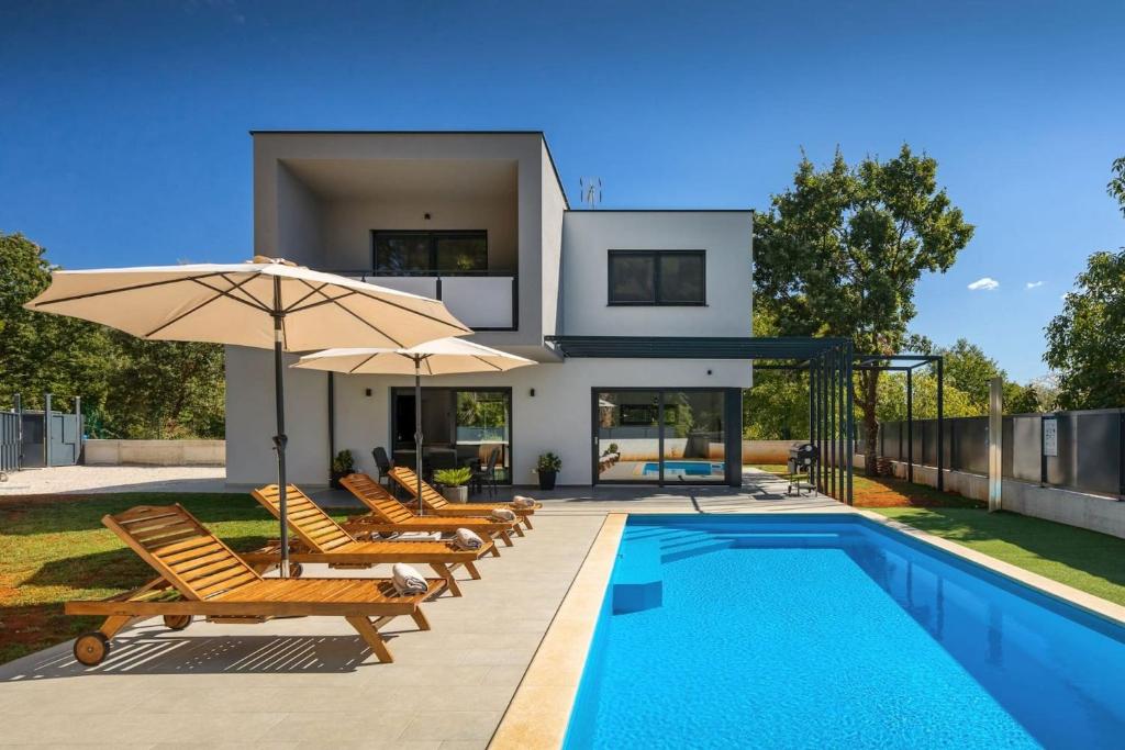 Casa con piscina con sillas y sombrilla en Modern villa Eva with pool and 2 bedrooms in Tar, en Tar