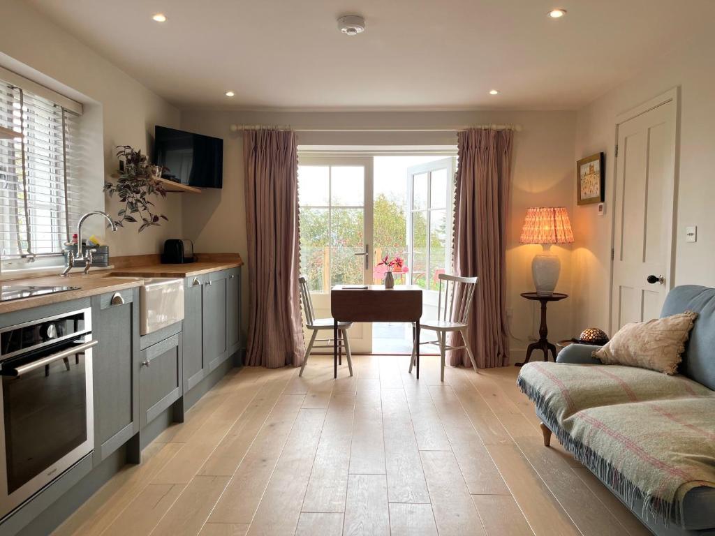 a kitchen and living room with a couch and a table at Cobblers Lodge in Lyme Regis