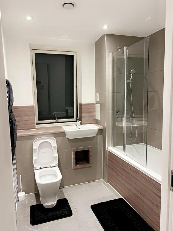 a bathroom with a toilet and a sink and a shower at Hommies homes in Barking