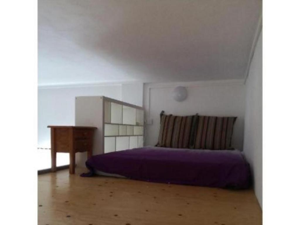 蒂亞斯的住宿－Ca' Anibal，一间卧室配有一张紫色的床和一张桌子