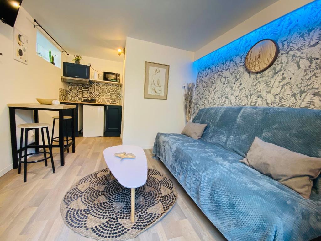 - un salon avec un canapé bleu et une table dans l'établissement Charmant studio à Talence, à Talence