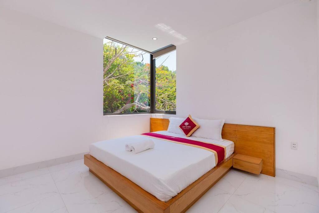 - une chambre avec un lit et une grande fenêtre dans l'établissement 31 Viba - Villa Vũng Tàu, à Vung Tau