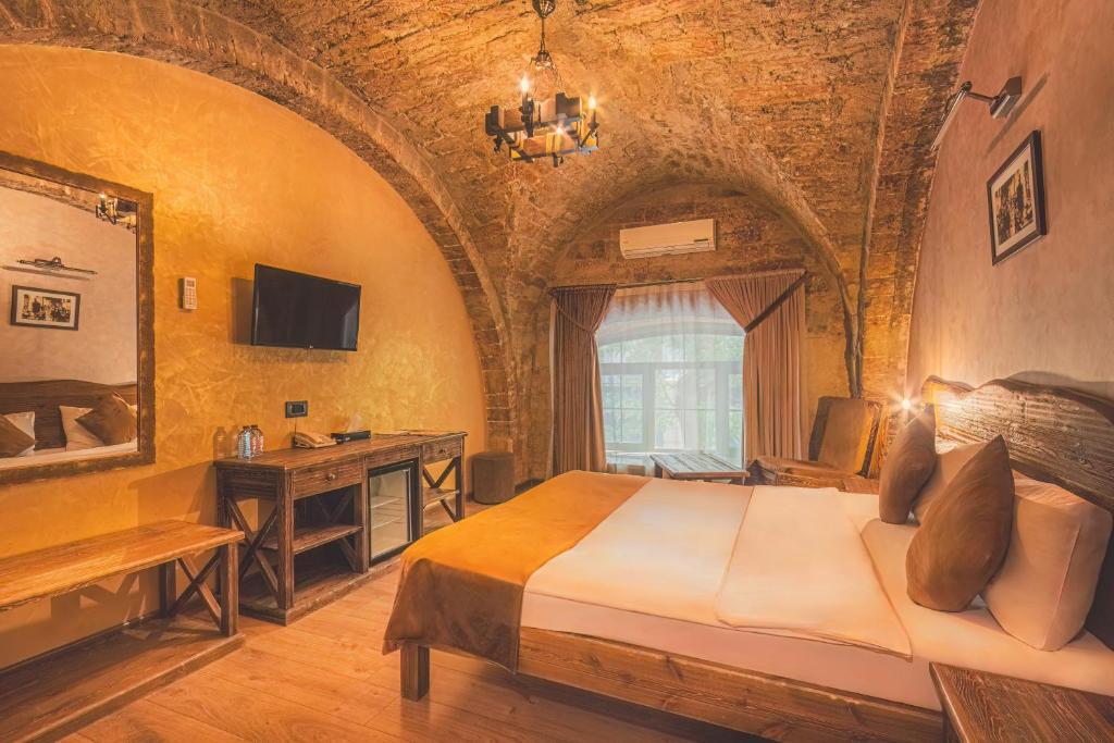 - une chambre avec un lit et un bureau dans l'établissement Passaje Old, à Baku