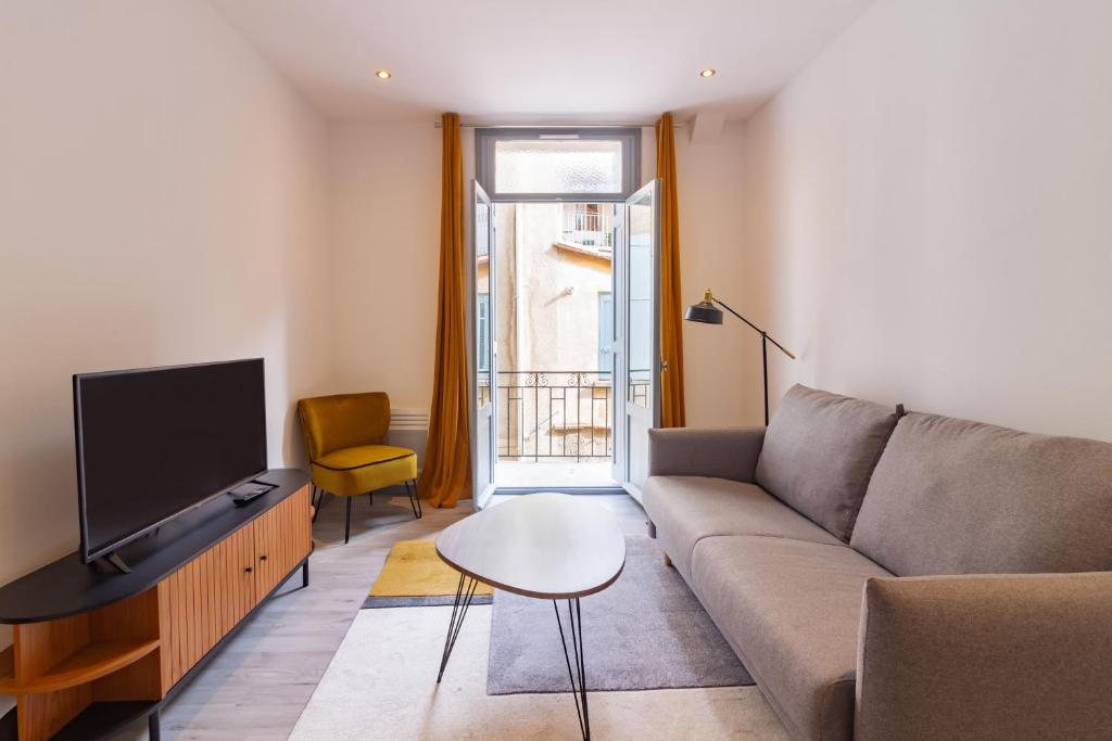 un soggiorno con un divano, una TV e un tavolo di Appartement moderne et élégant quartier Saint-Jean Perpignan 2 a Perpignano