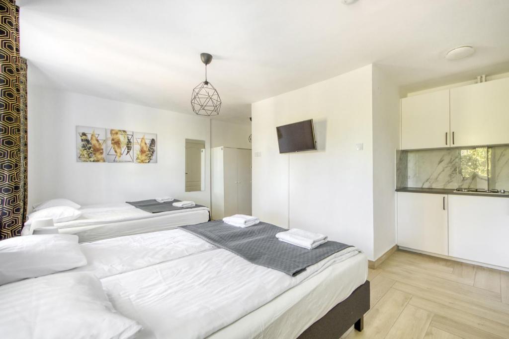 華沙的住宿－Labo Apartment Niepodległości，卧室设有2张床和白色的墙壁。